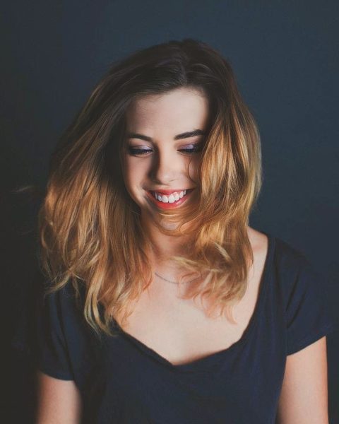 Miranda Sita, founder of Bainbridge Death Support, smiling and looking down, her long hair falling past her shoulders.